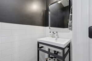 Bathroom with a sink and tile walls