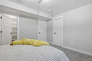 Bedroom featuring a walk in closet and light colored carpet