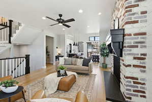 Living area with light wood-style flooring, a ceiling fan, and recessed lighting