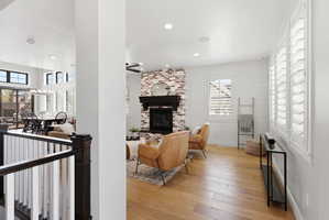 Living room with light wood finished floors, a fireplace, and recessed lighting