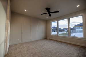 Master Bedroom featuring a decorative wall, a ceiling fan, light colored carpet, and recessed lighting