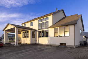 Rear view of house with stucco siding and a patio area