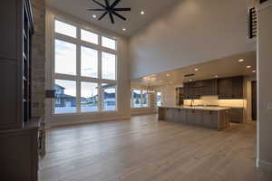 Unfurnished living room with hanging lights, and a high ceiling