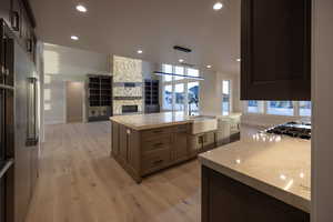 Kitchen with a spacious island, open floor plan, light wood-style tile flooring, light counters