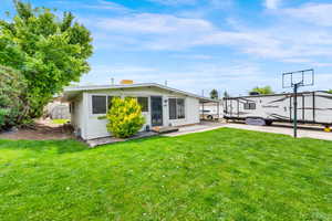 Back of house with a yard and a shed