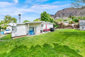 Rear view of house with a yard and a patio