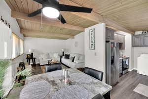 Dining room with dark wood-style floors, washer / clothes dryer, a wooden ceiling with exposed beams, and ceiling fan