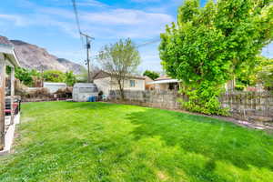 Fenced backyard featuring a shed