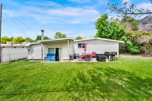 Back of property featuring a patio area and a yard