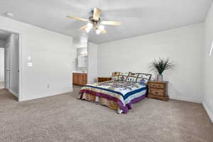 Bedroom featuring light colored carpet, ceiling fan, a textured ceiling, and ensuite bathroom