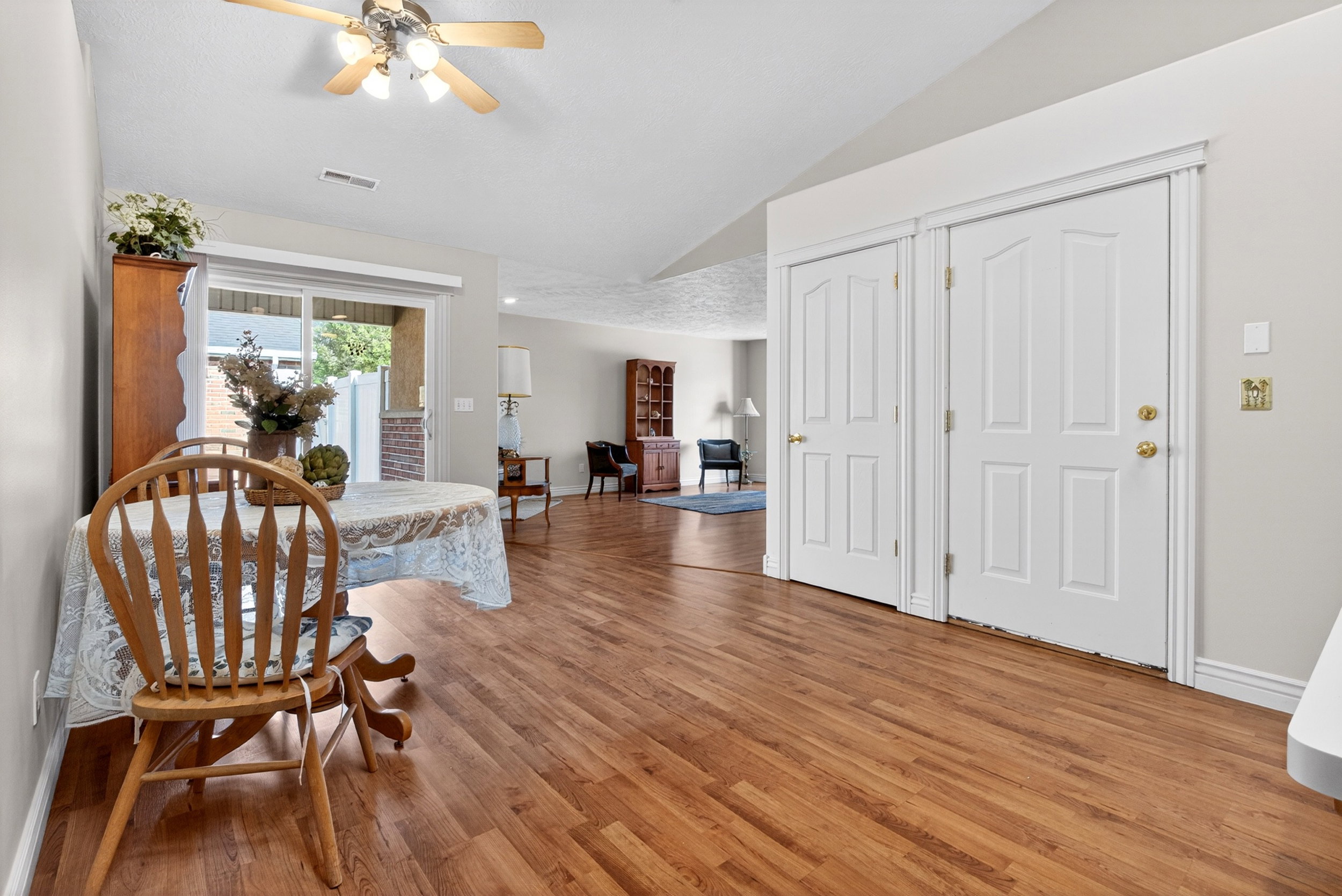 Dining area with ceiling fan, light wood finished floors, and lofted ceiling