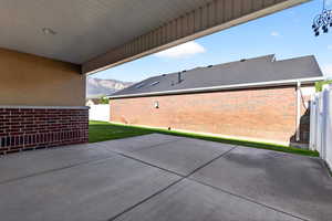 Fenced backyard featuring a patio and a mountain view