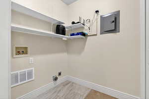 Laundry room featuring electric panel and hookup for a washing machine