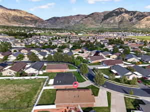 Aerial view of property and surrounding area with mountains and nearby suburban area