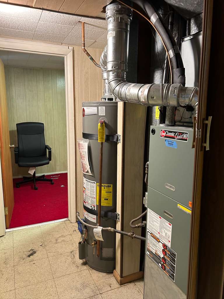 Dedicated utility space featuring a water heater and furnace unit