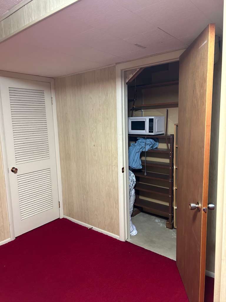 Wood-paneled wall surfaces with a contrasting red carpet flooring