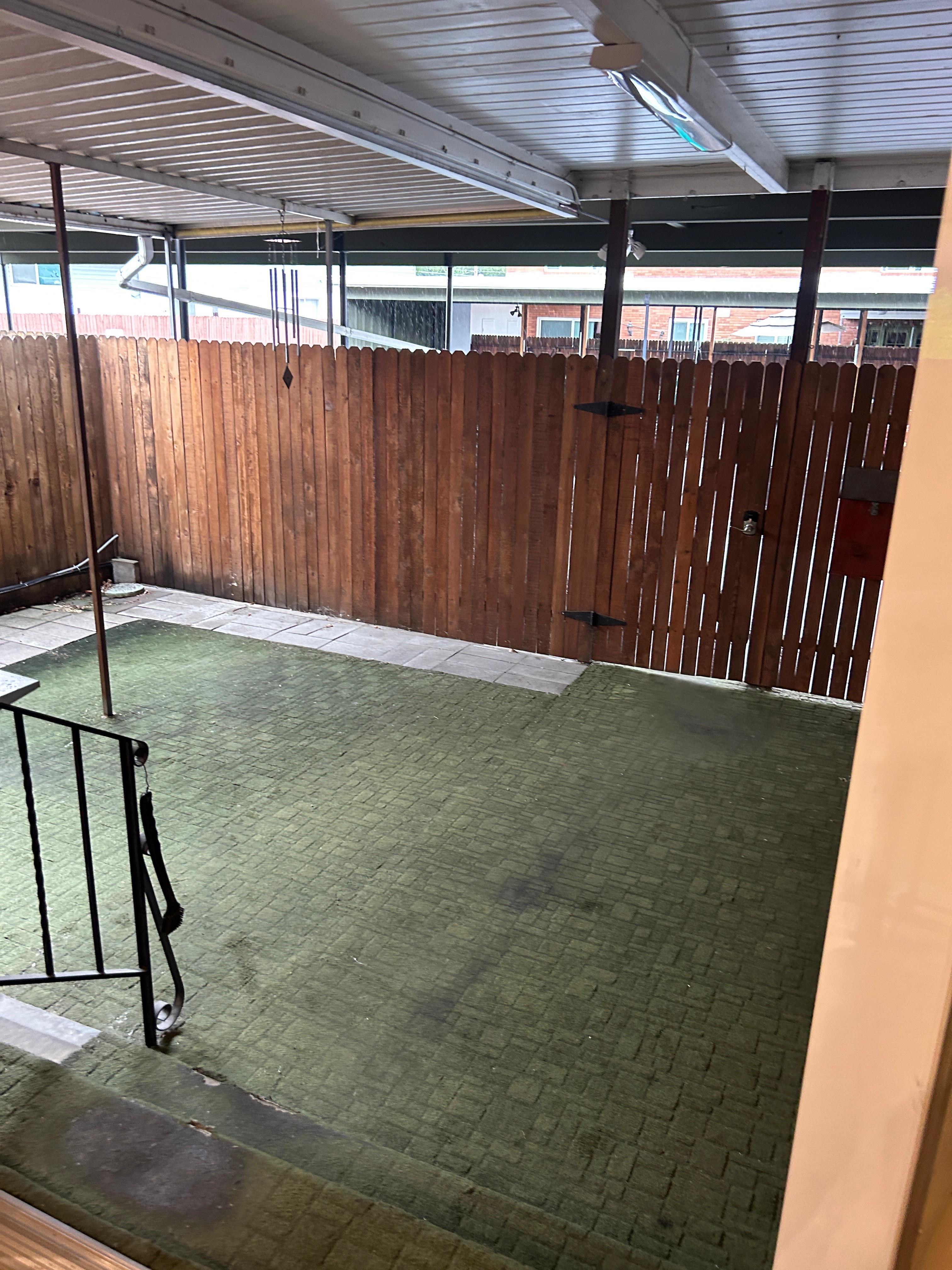 Covered patio area featuring a textured green floor