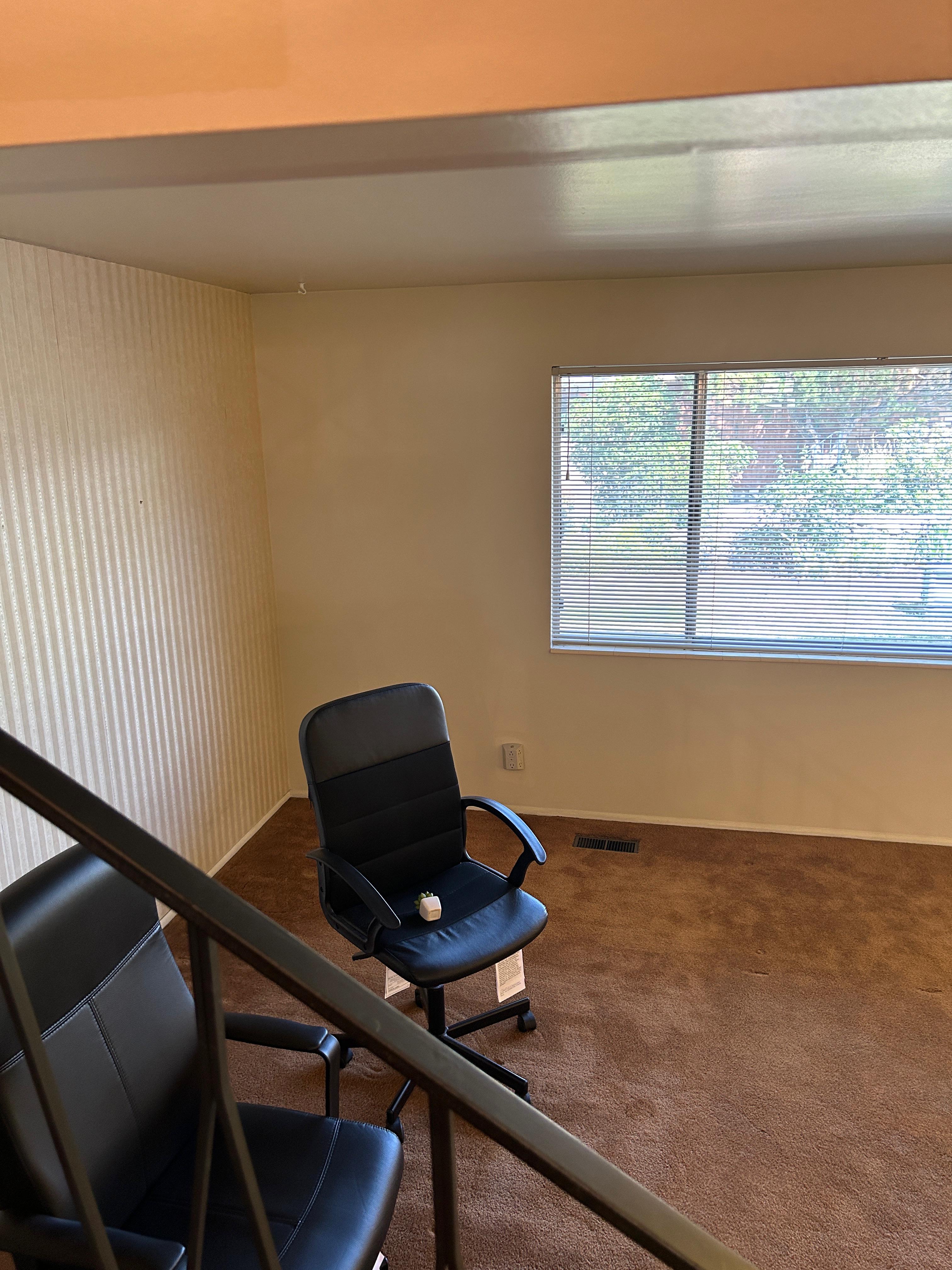 Carpeted interior space featuring a window with horizontal blinds