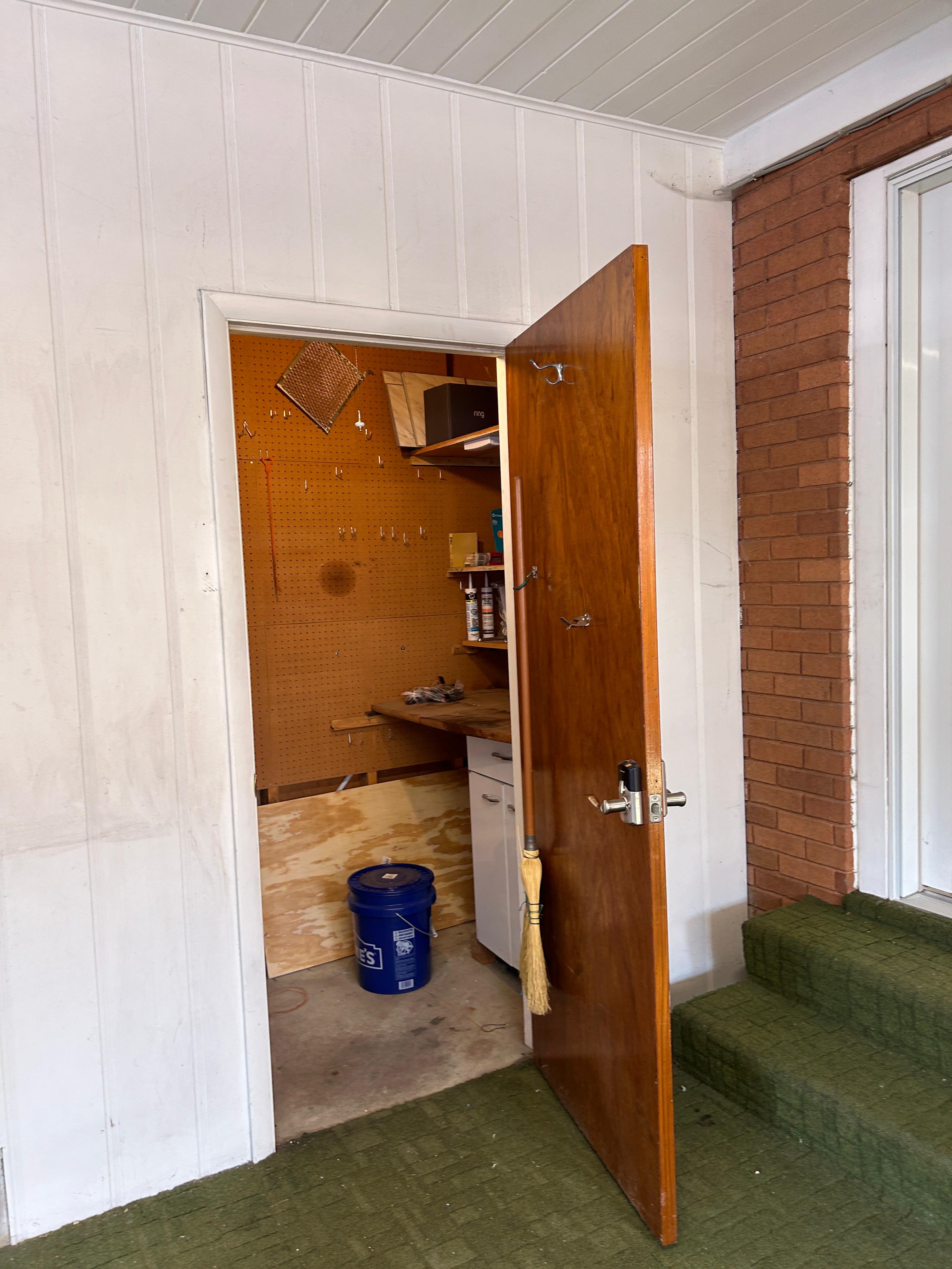 Utility space with pegboard wall, built-in shelving, and a work surface