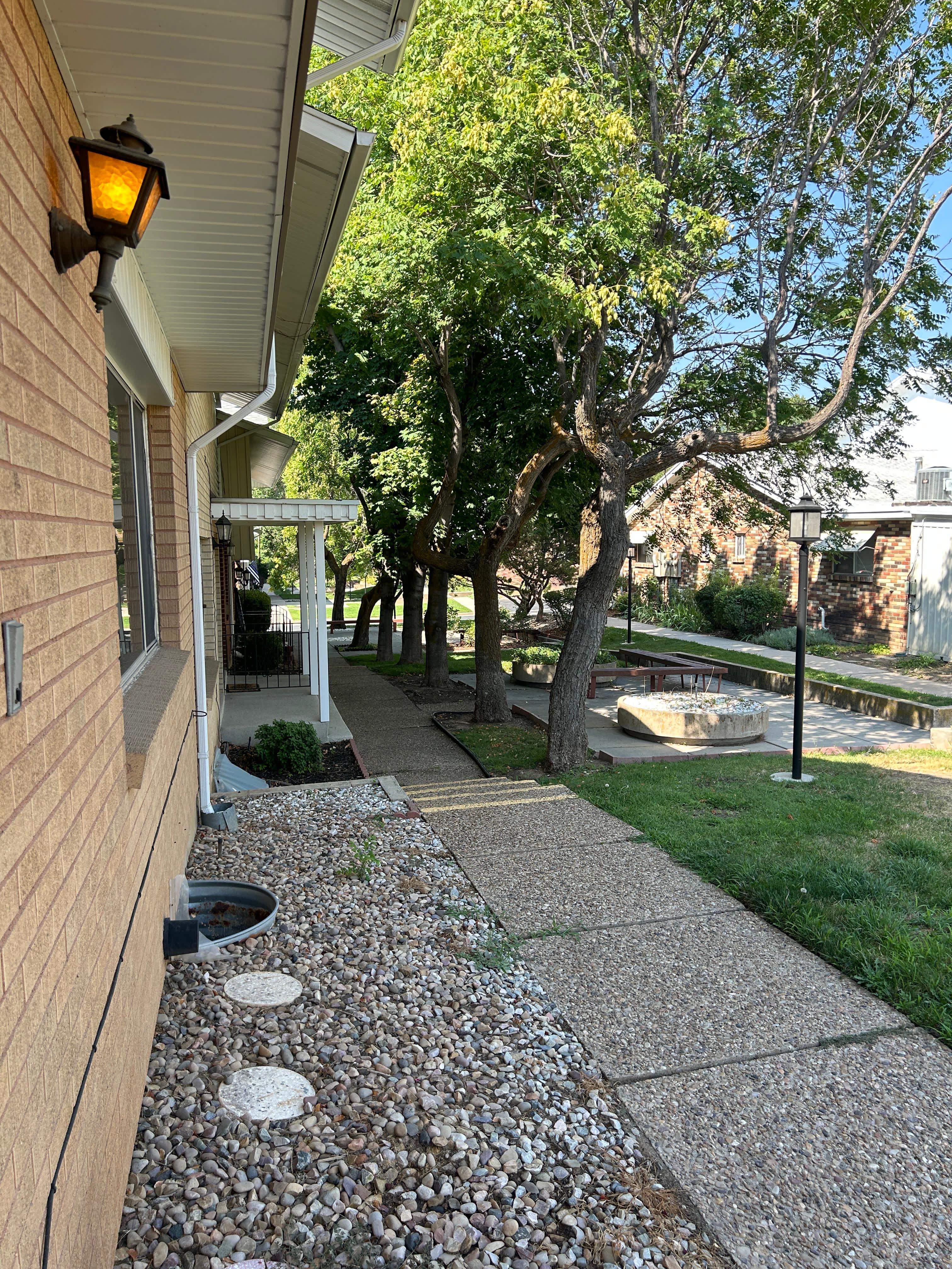 Brick exterior with a traditional wall-mounted lantern and a gravel rock bed