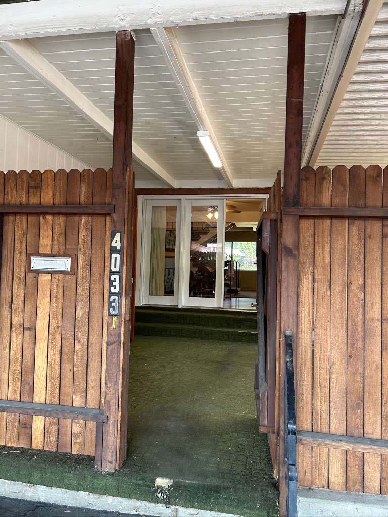 Covered entry with a wood-finish fence and white paneling overhead