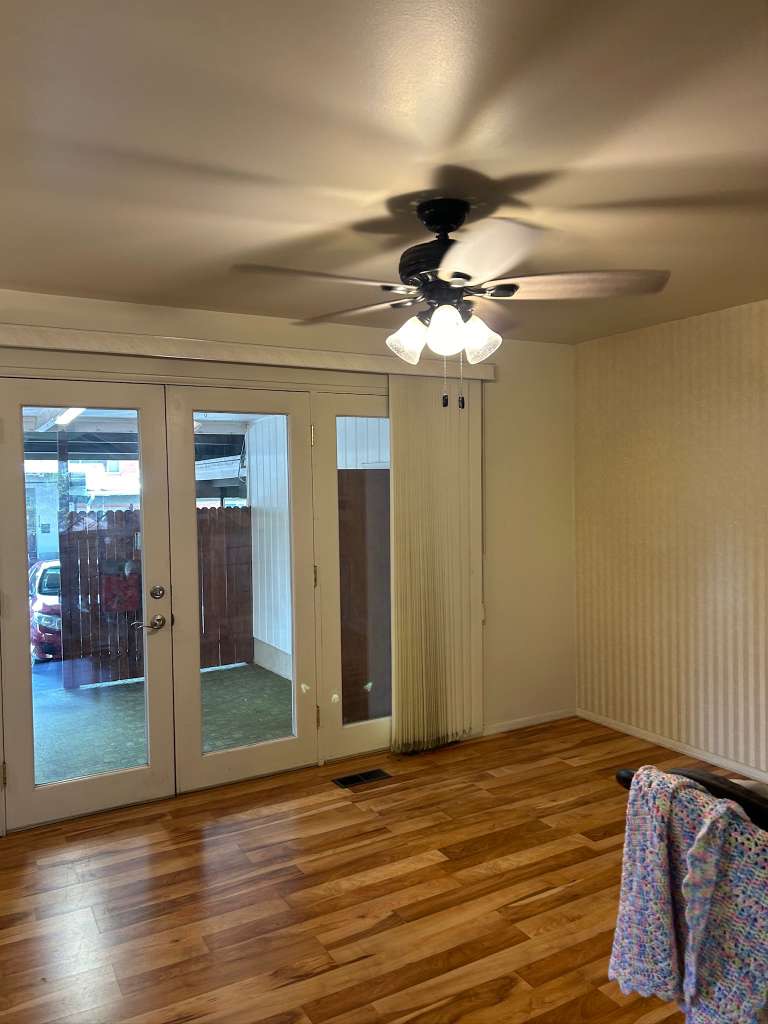 Wood-finish flooring throughout, complemented by a ceiling fan with integrated lighting