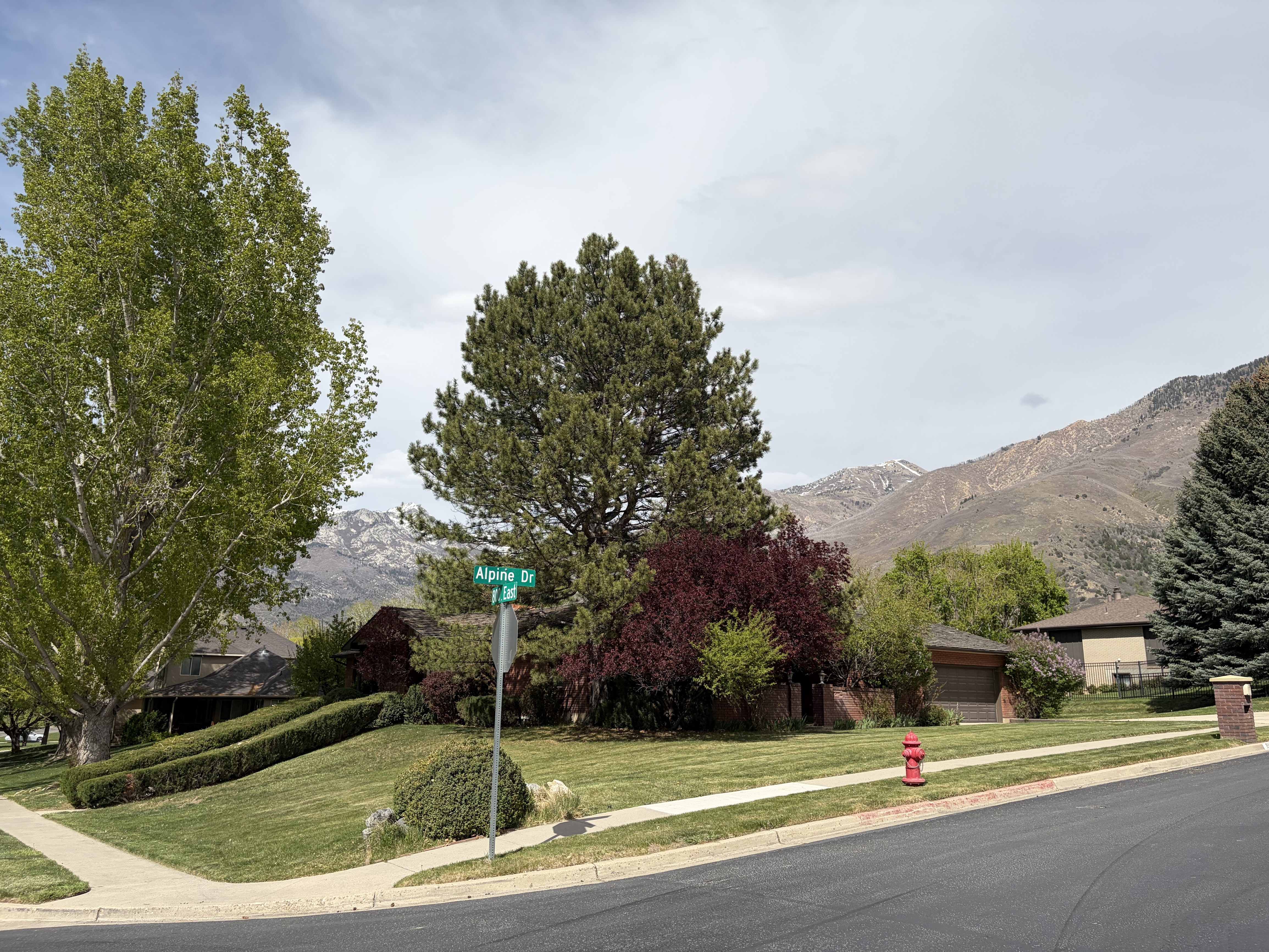 View of asphalt street with sidewalks, a mountain view, and traffic signs