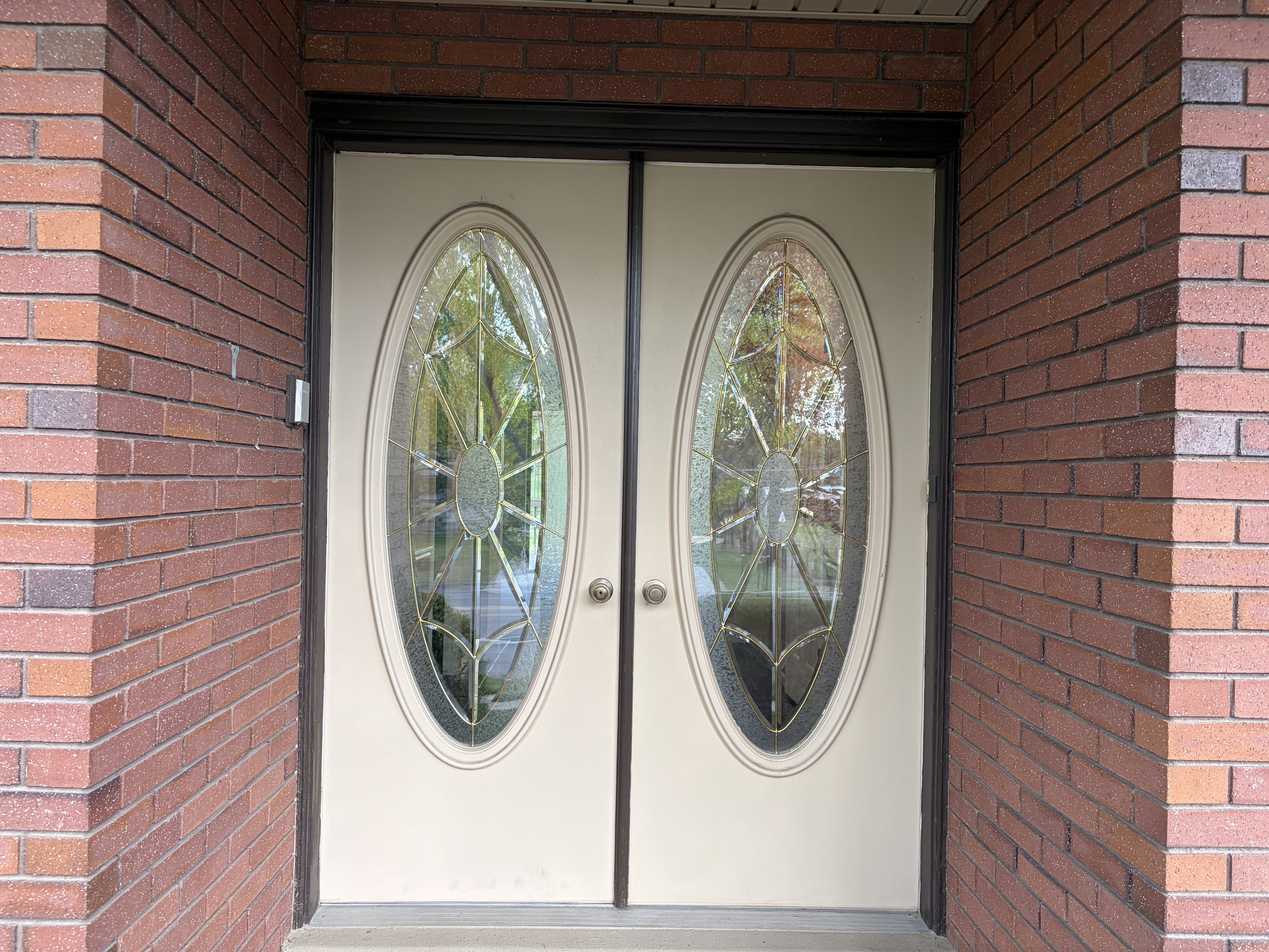 View of exterior entry featuring brick siding and french doors
