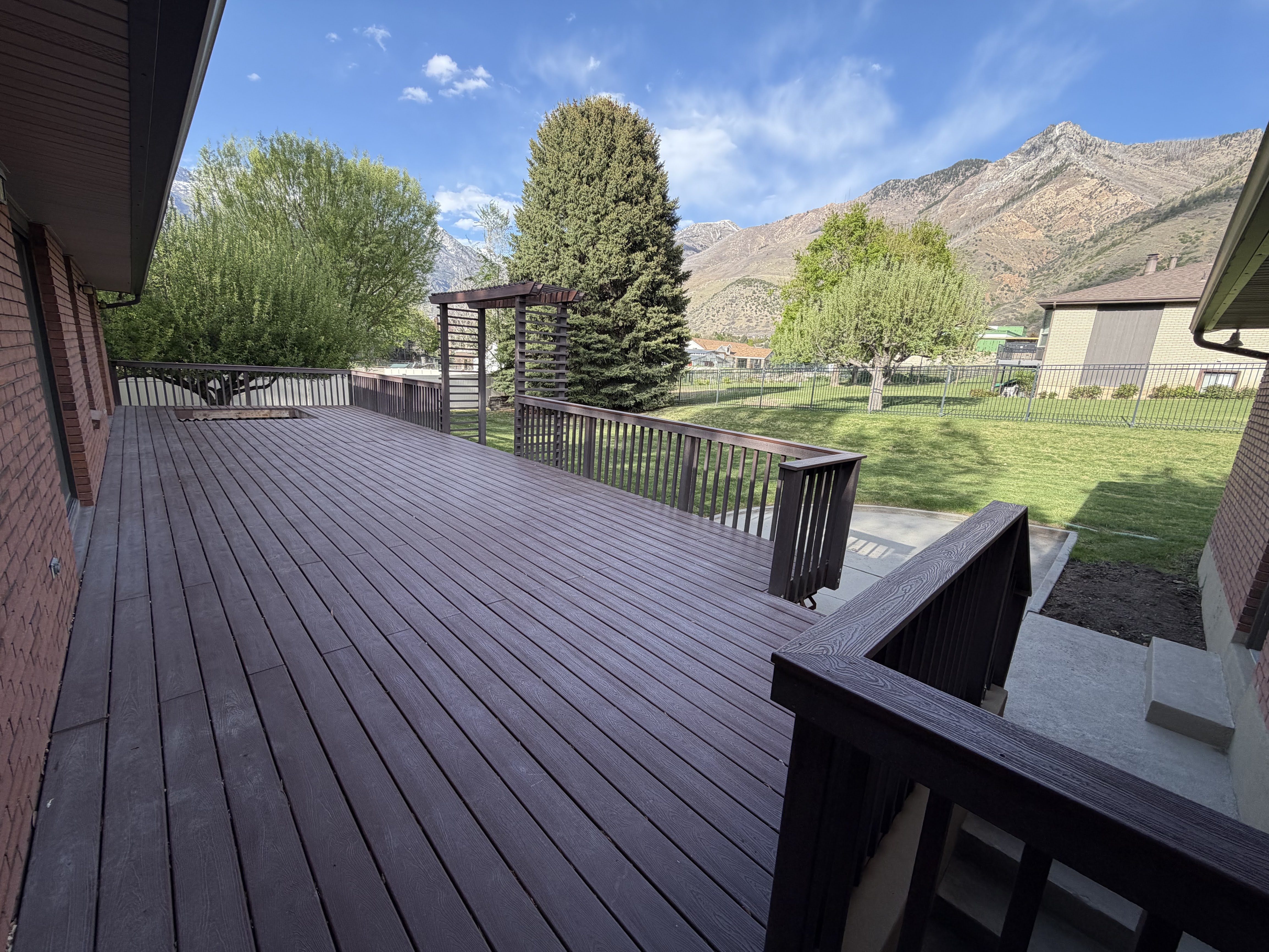 Deck with a mountain view and a fenced backyard