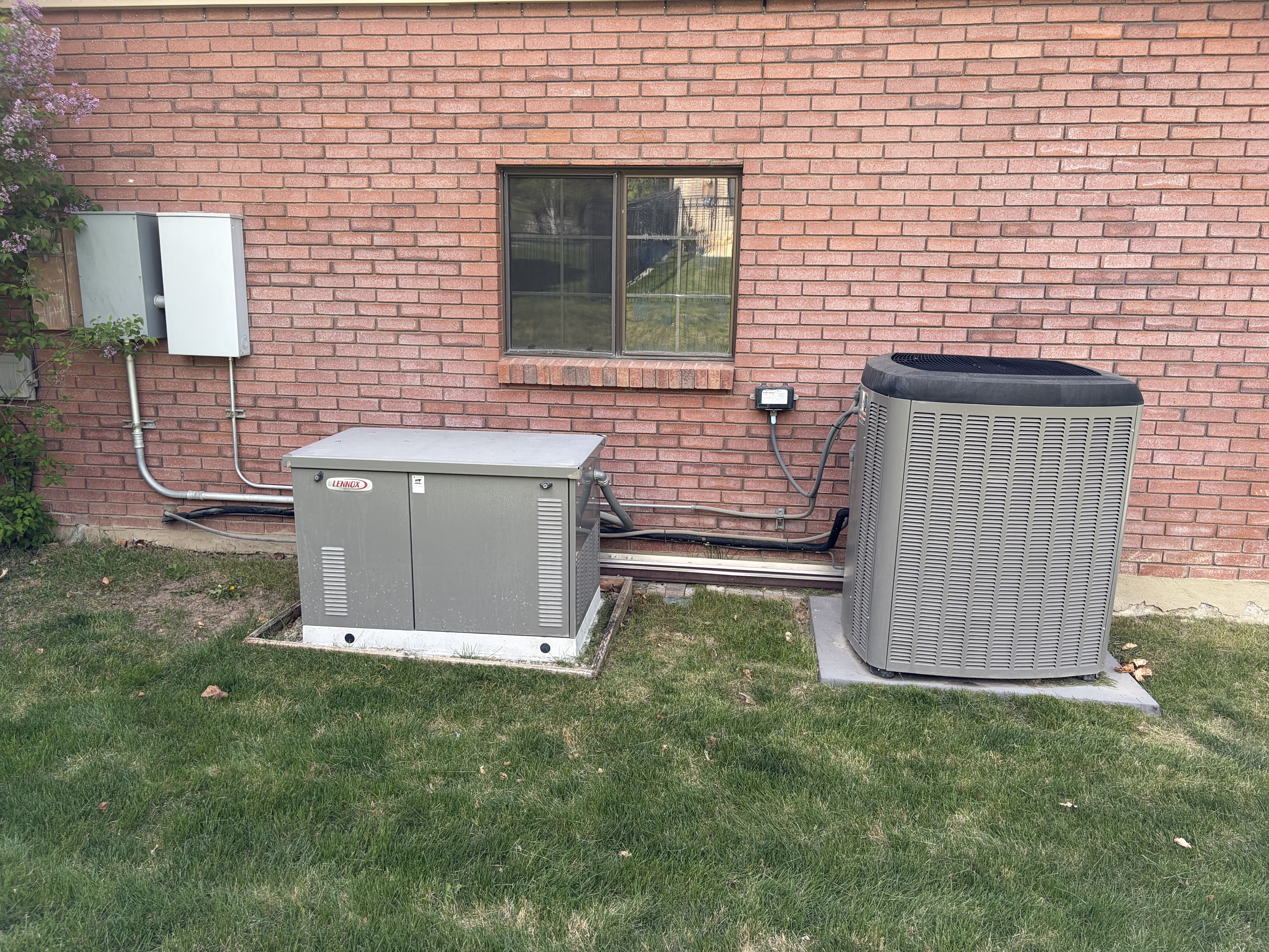 Exterior view of a cooling unit and brick siding