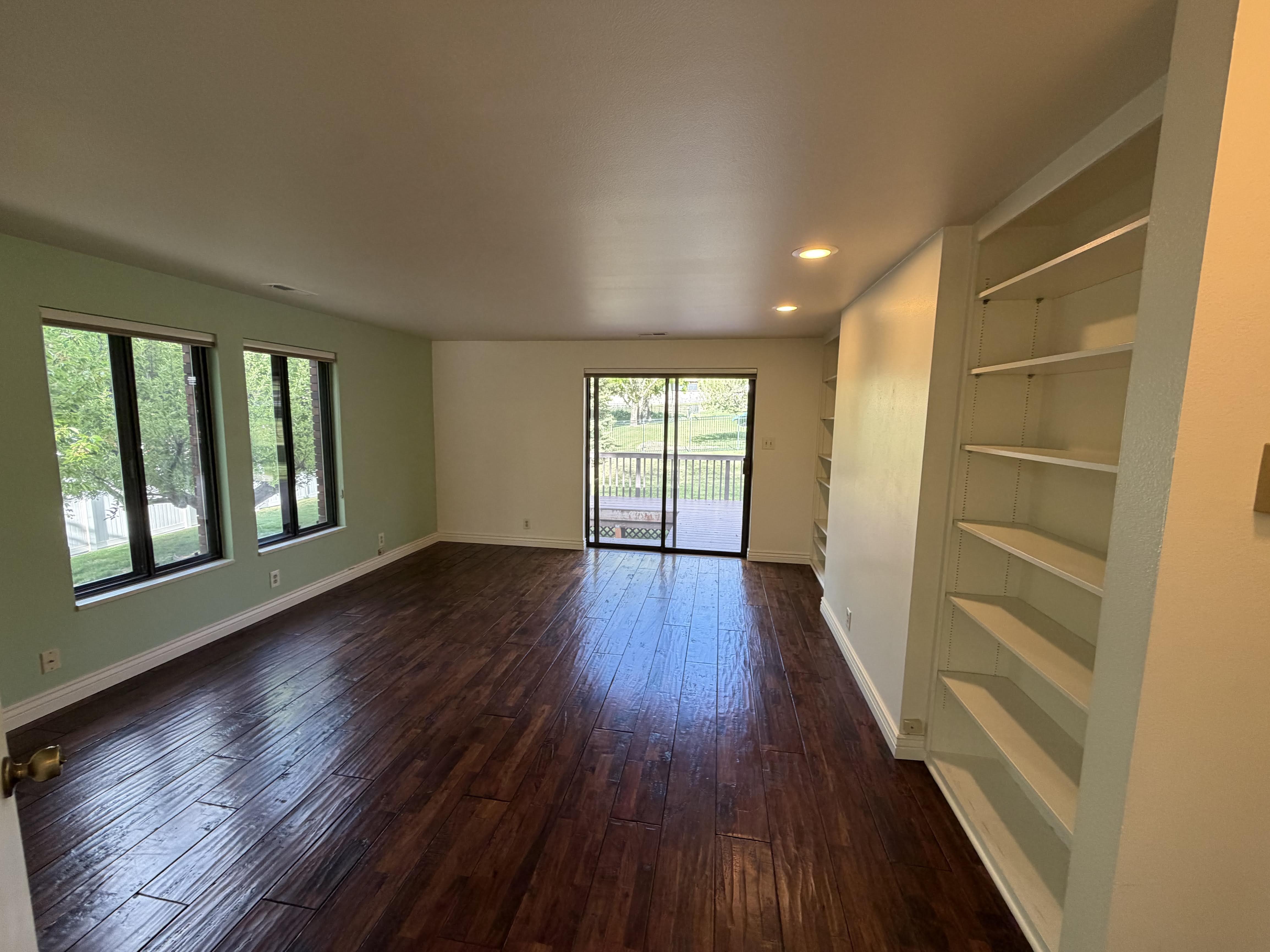 Unfurnished room with dark wood-type flooring, recessed lighting, and built in shelves