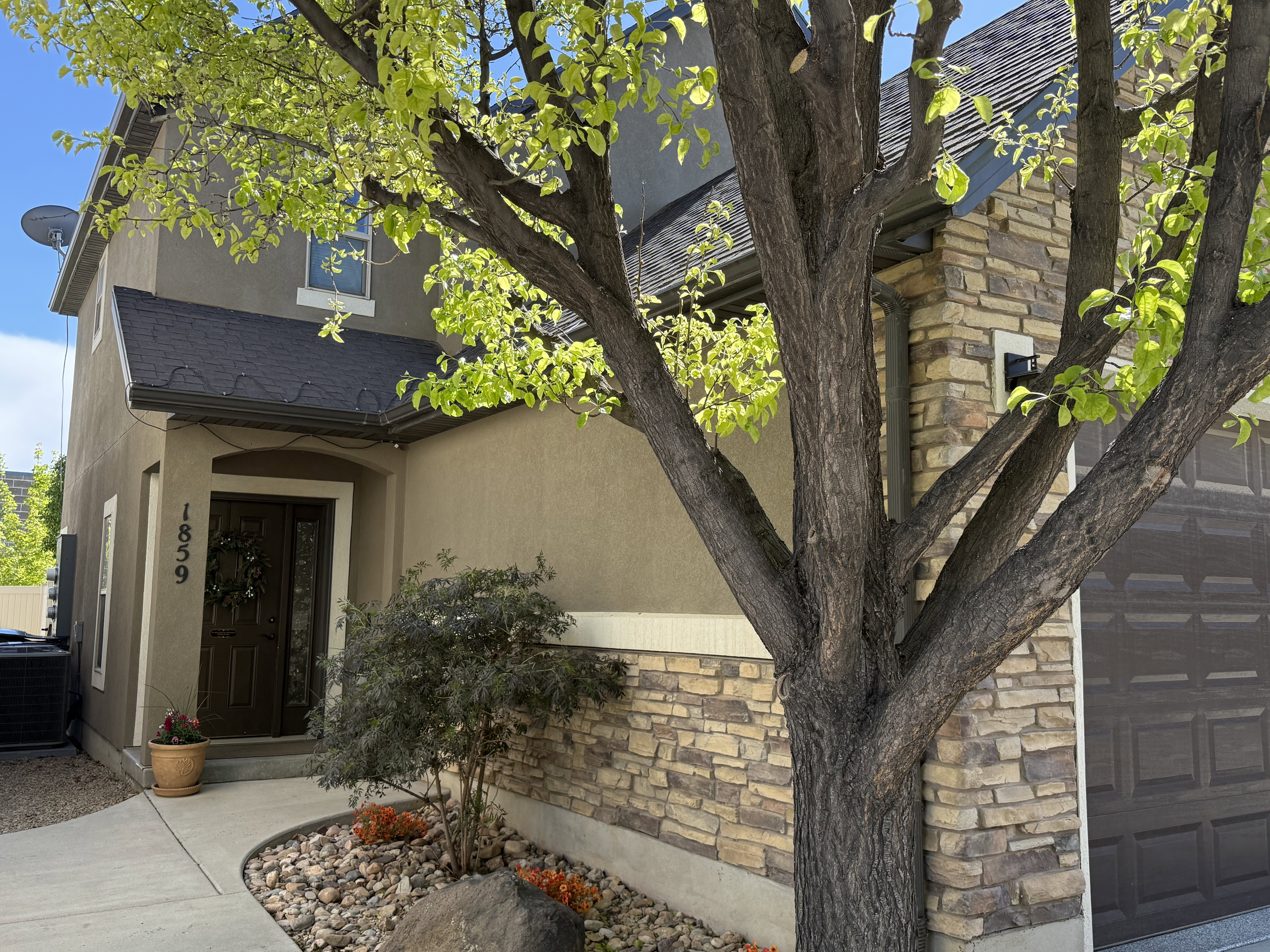 Entrance to property with stucco siding and stone siding