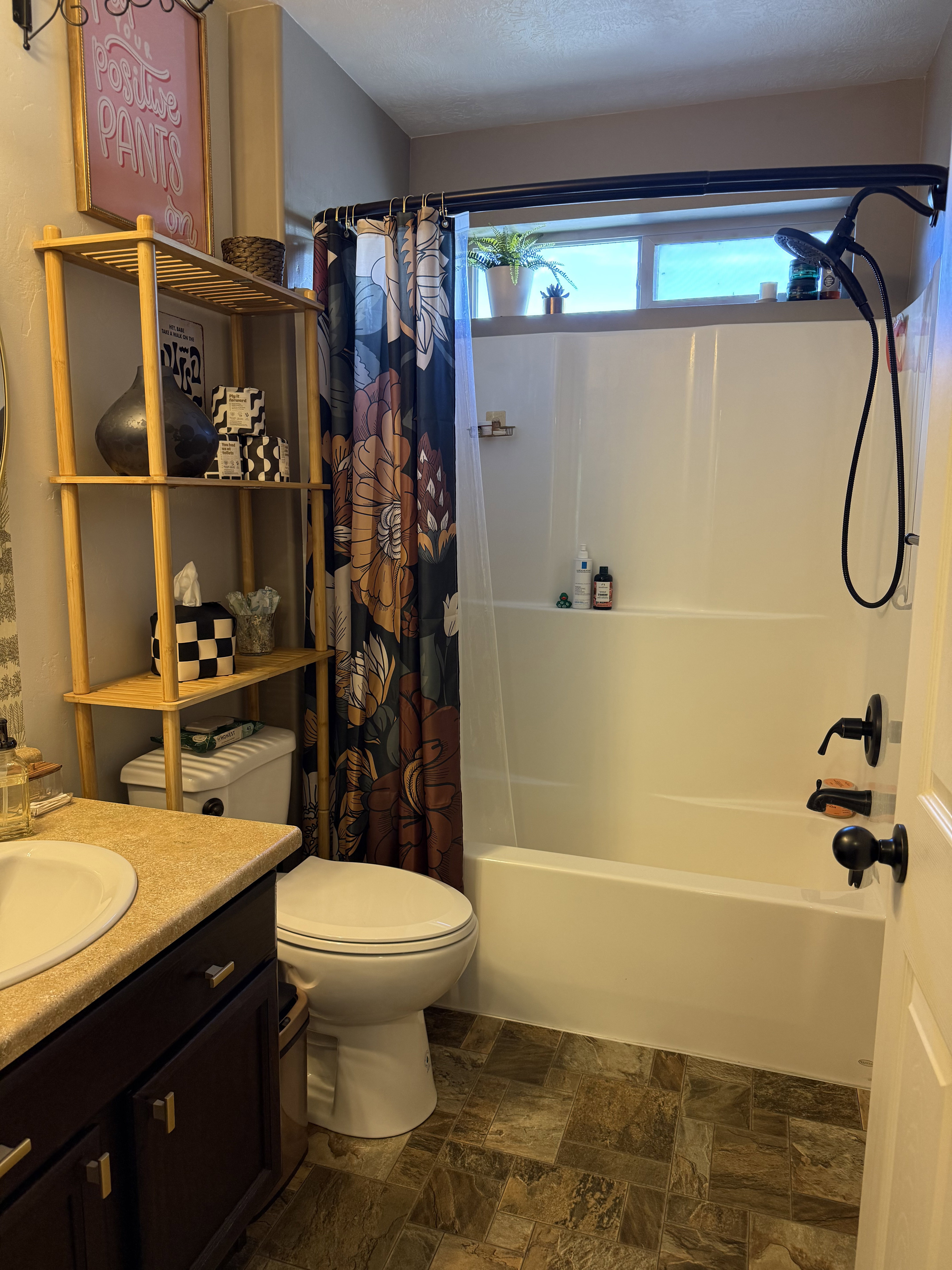 Full bathroom featuring stone finish flooring, vanity, shower / tub combo with curtain, and a textured ceiling