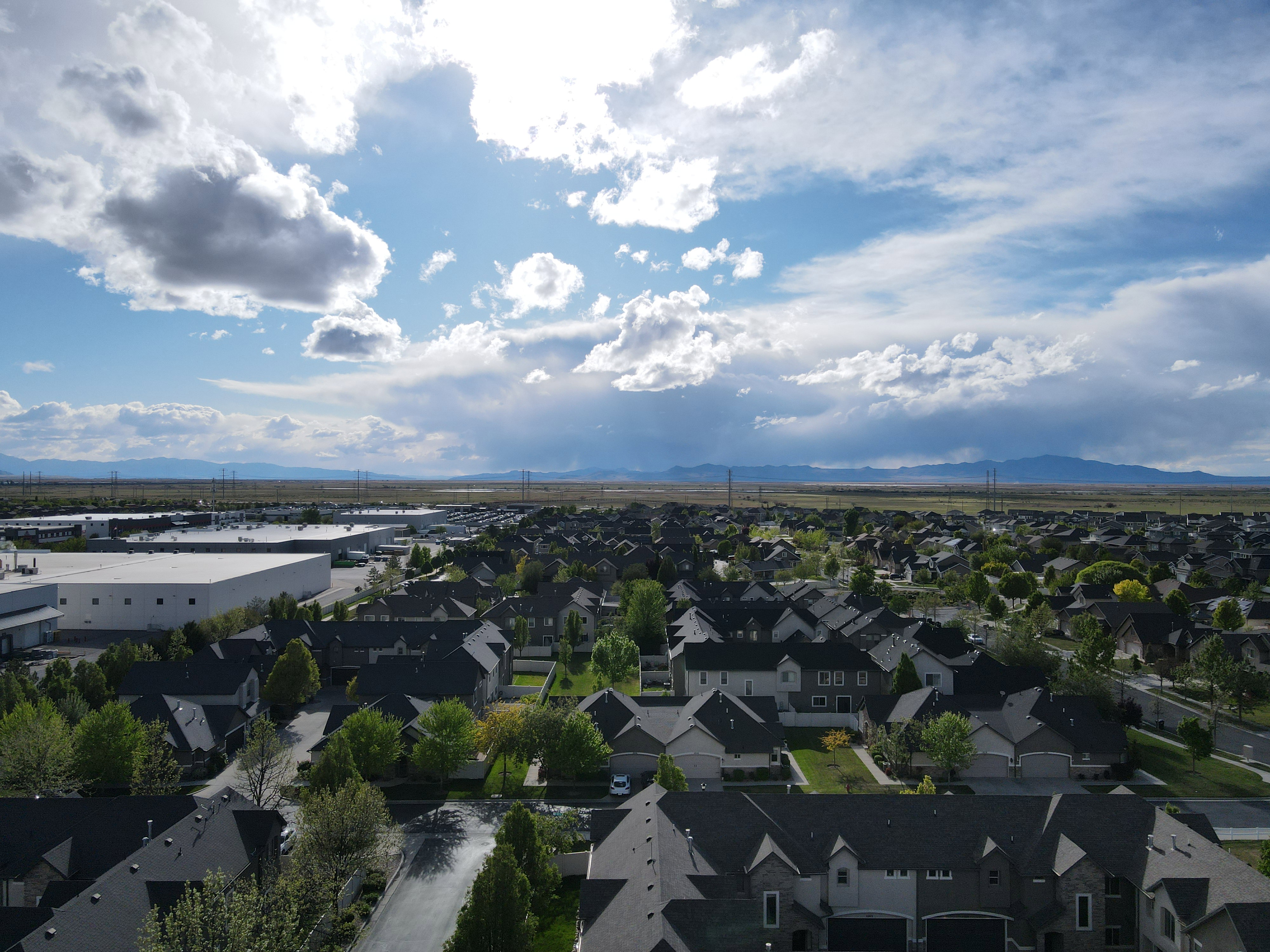 Aerial perspective looking west of suburban area featuring a mountainous background