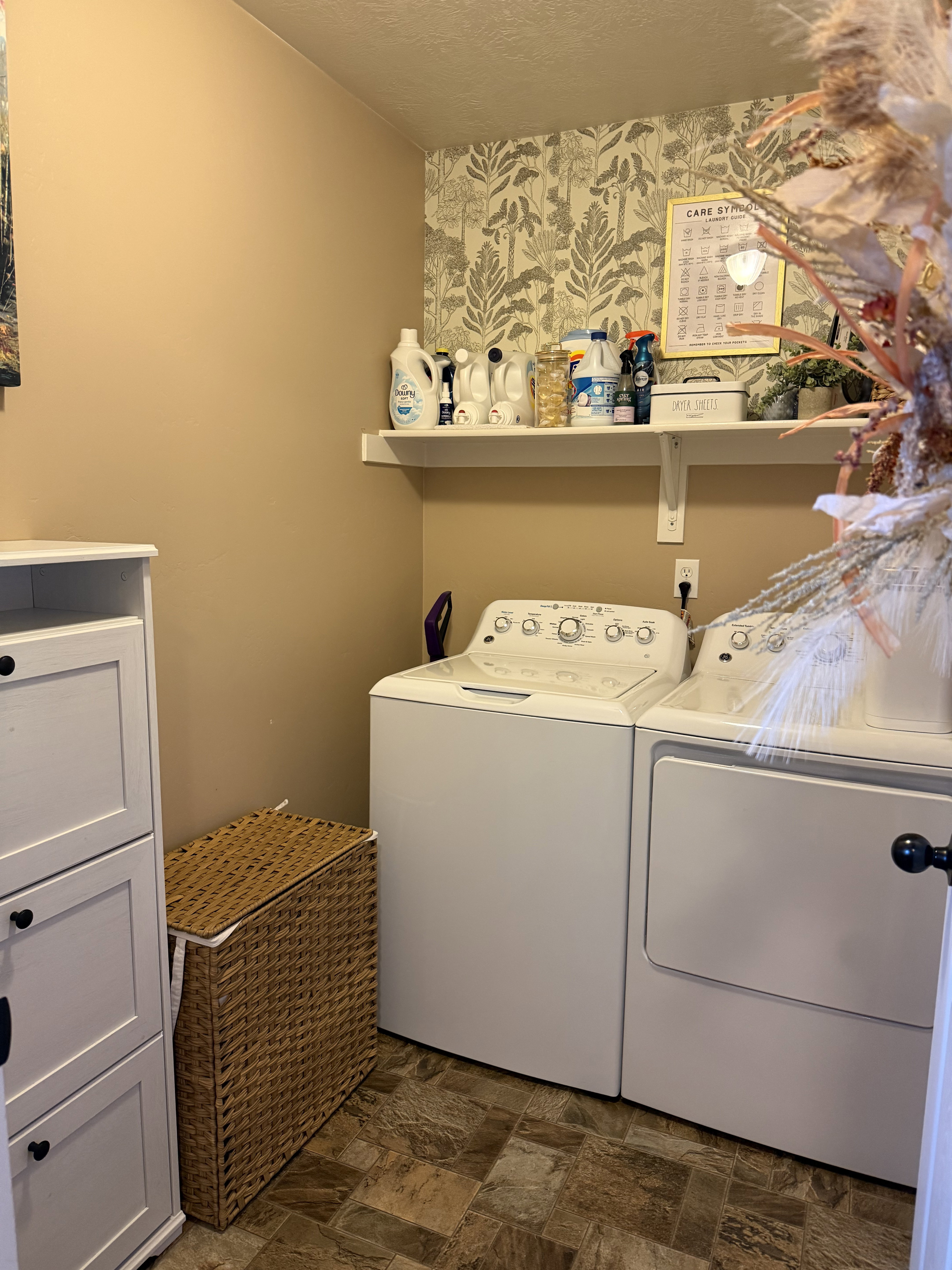 Laundry room with stone finish floors, independent washer and dryer, and a textured ceiling