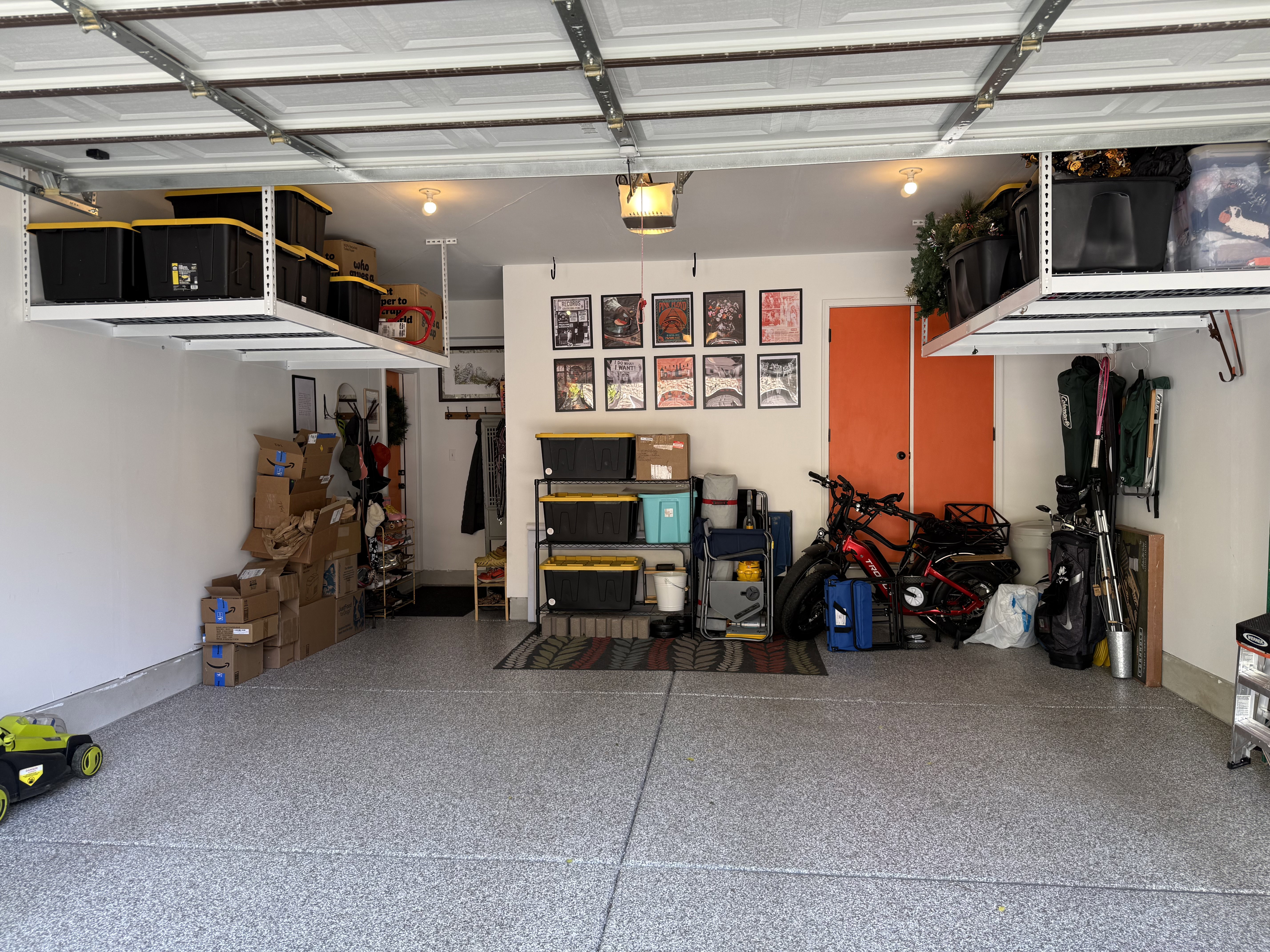 Garage featuring a garage door opener, epoxy flooring, and storage