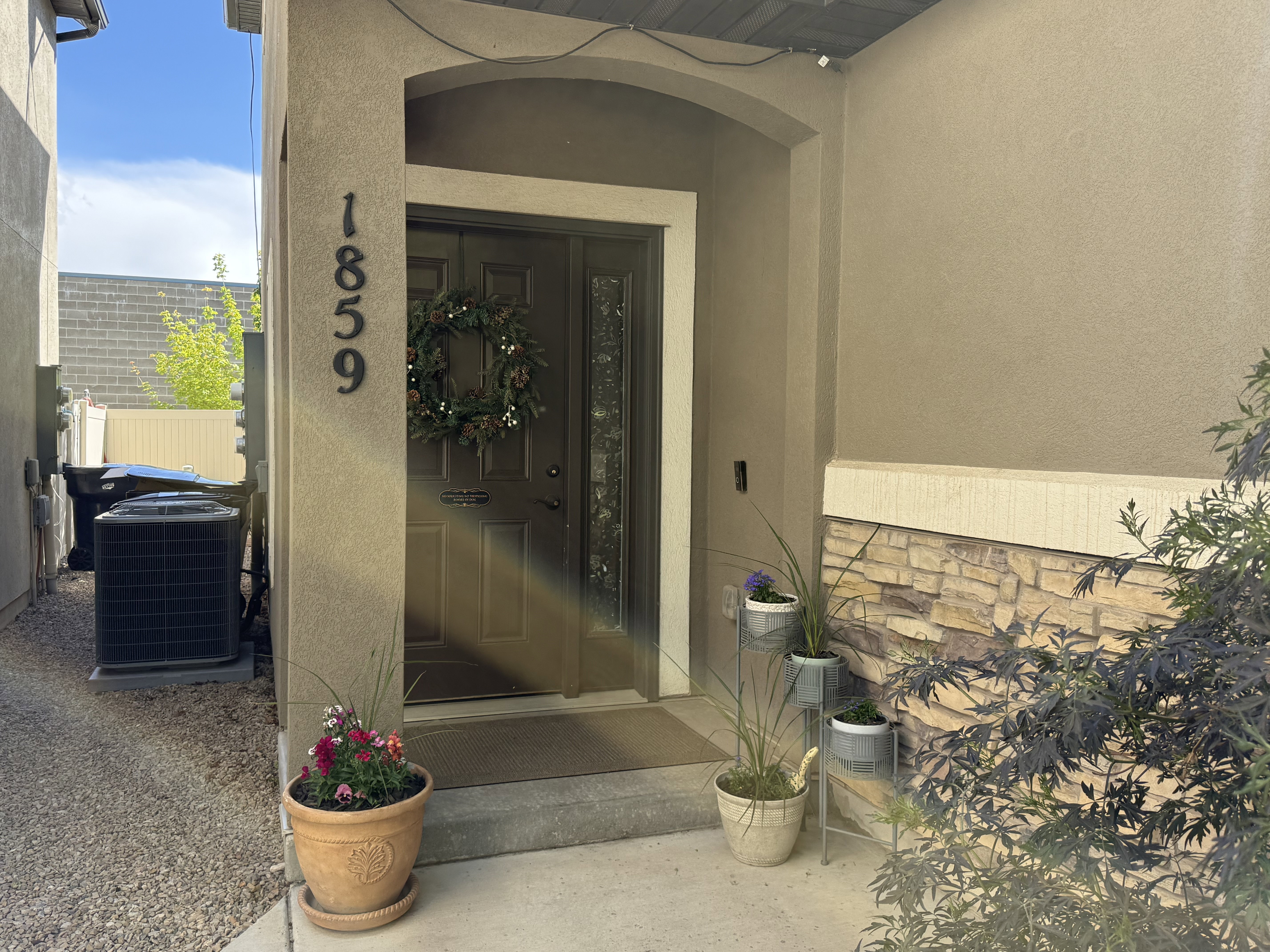 Entrance to property with stucco siding and stone siding