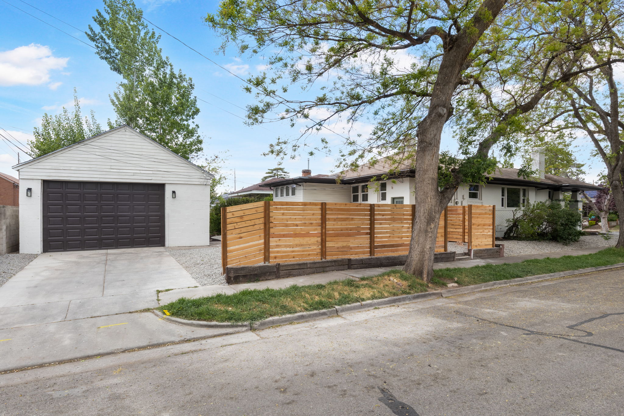 View of front of property featuring a fenced front yard, a garage, and an outdoor structure