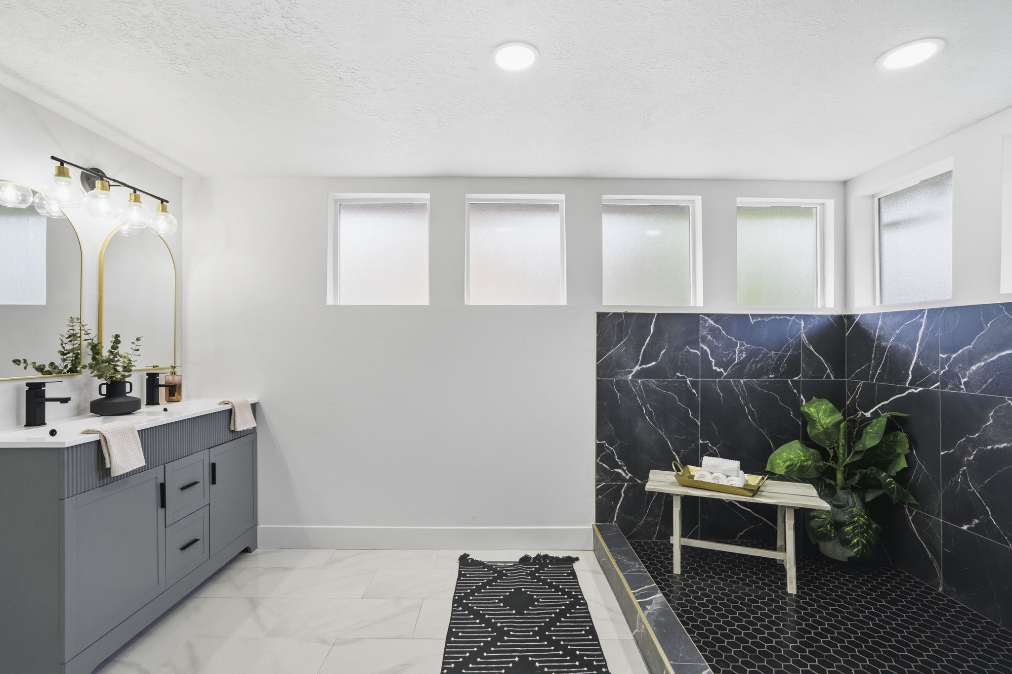 Bathroom featuring double vanity, a textured ceiling, and recessed lighting