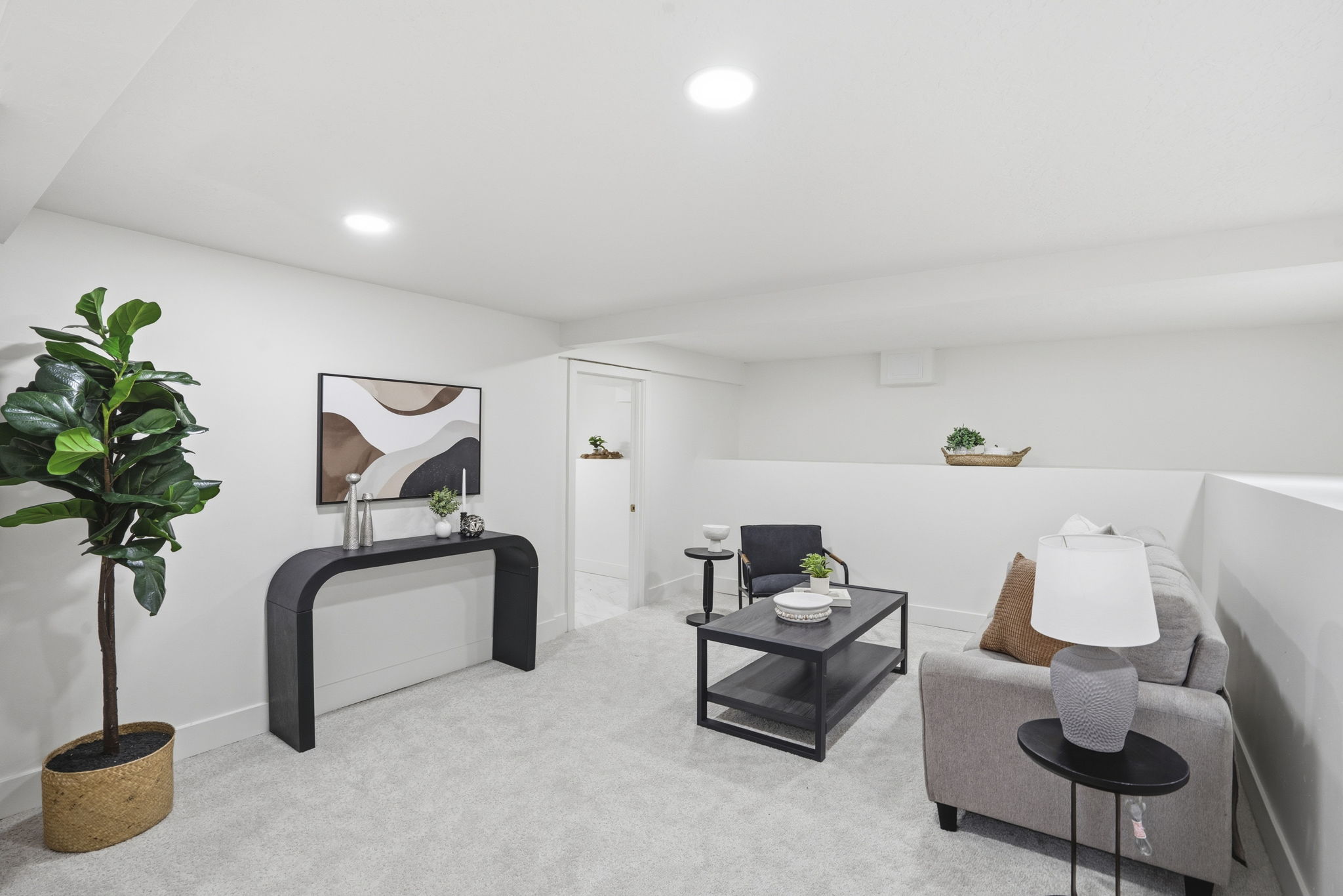 Living area with light carpet and recessed lighting