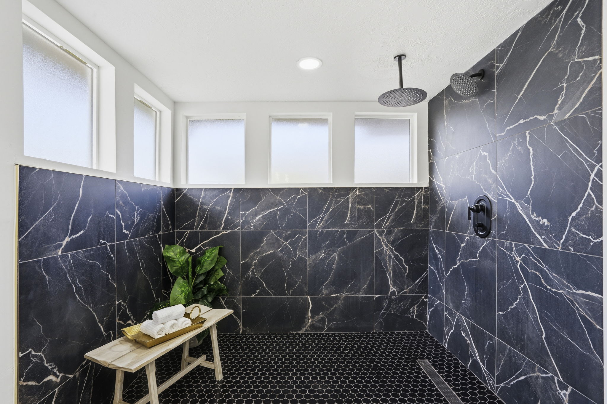 Bathroom featuring a marble finish shower and pet washing area