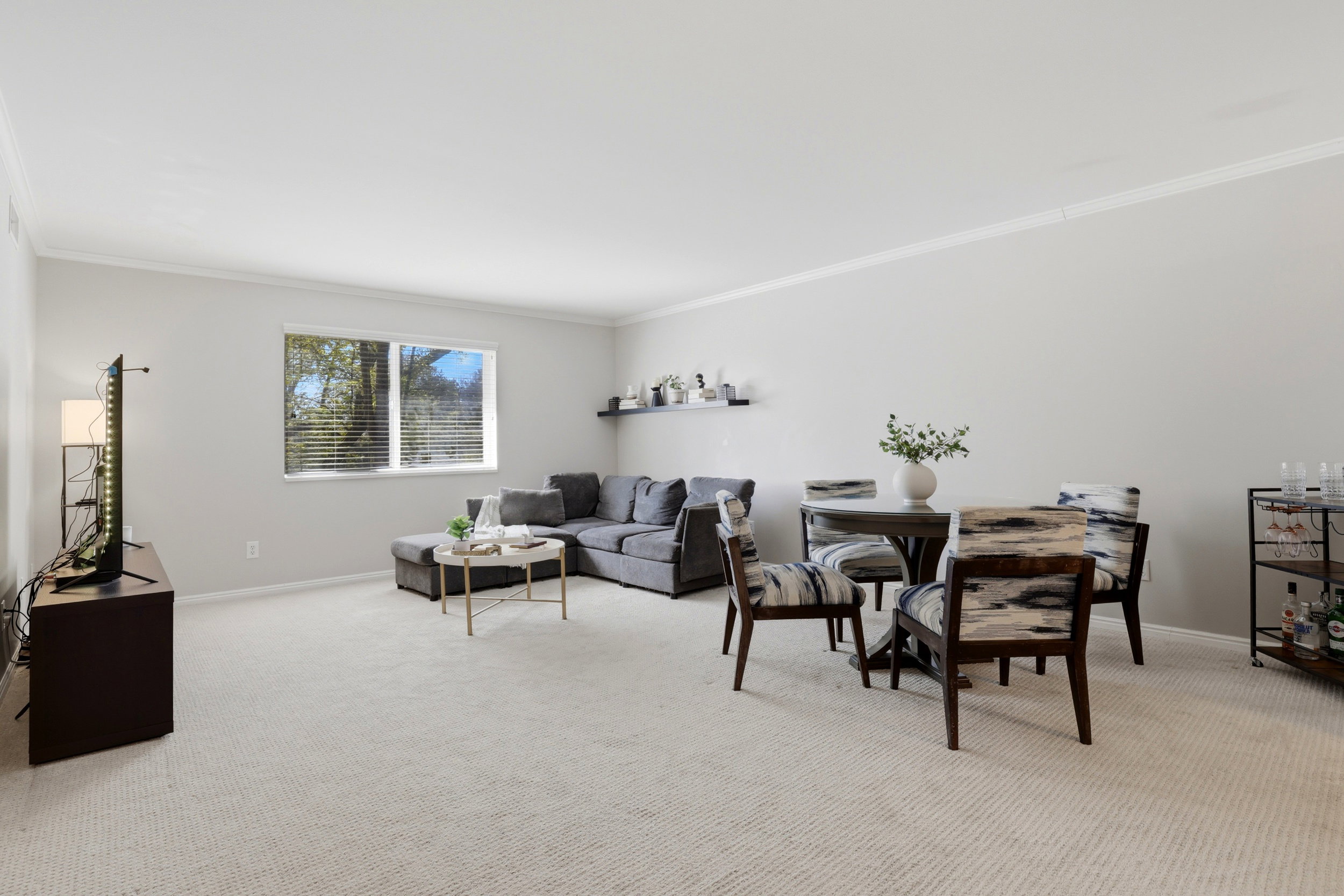 Living area featuring light colored carpet and crown molding