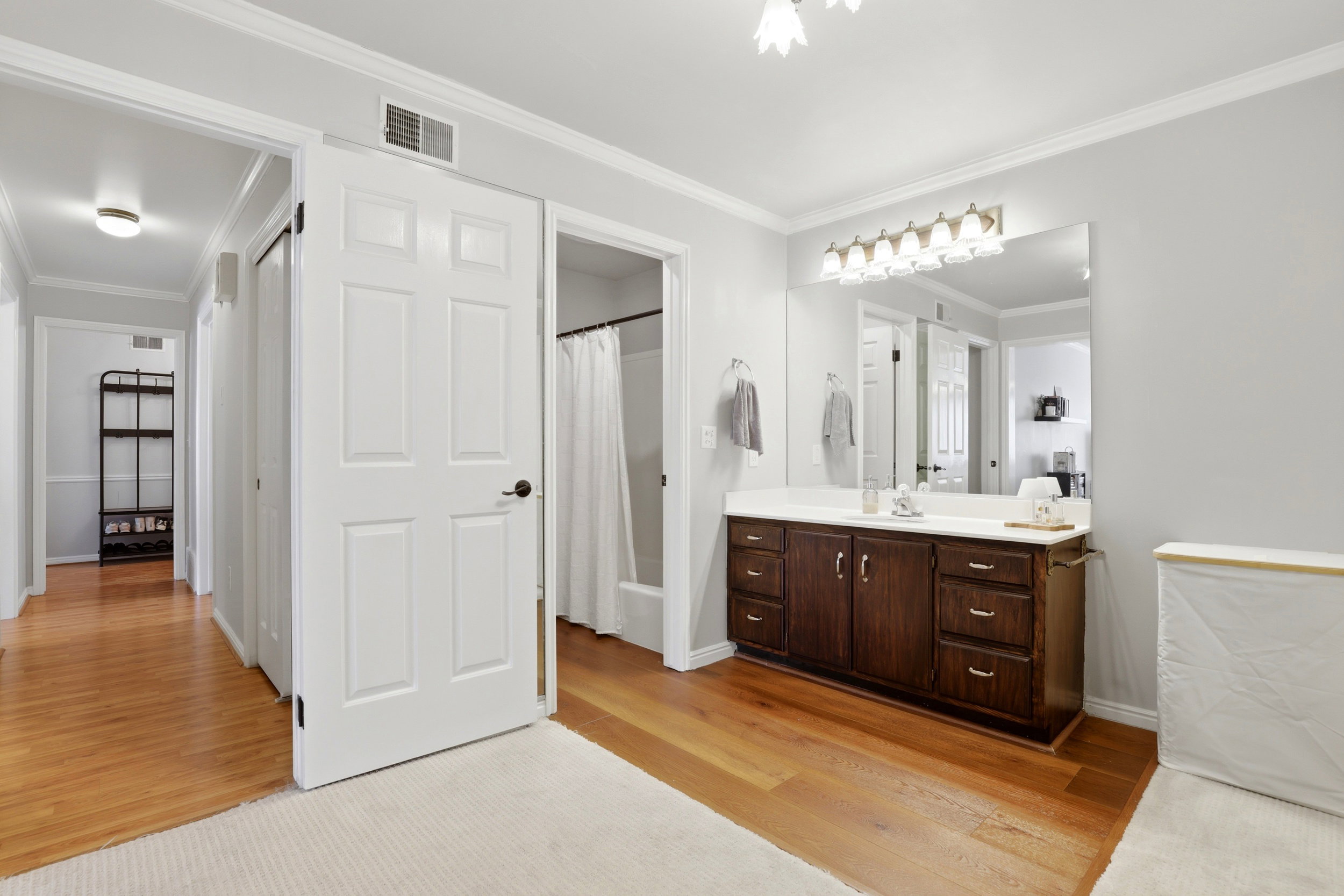 Bathroom with ornamental molding, vanity, and light wood-style flooring