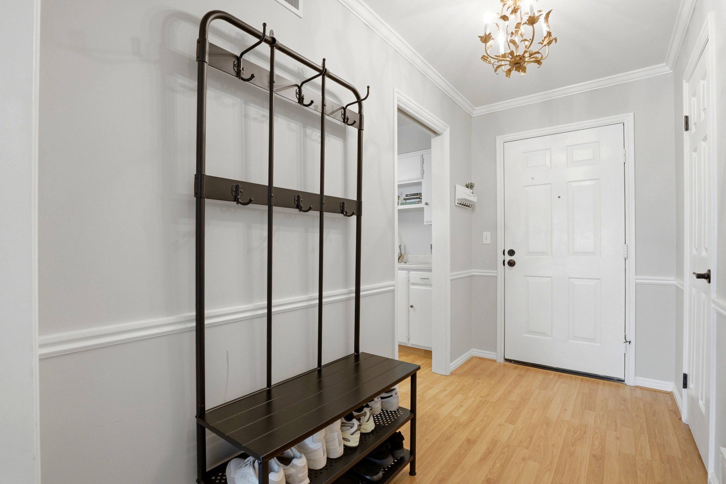 Mudroom featuring crown molding, light wood-type flooring, and suspended lighting