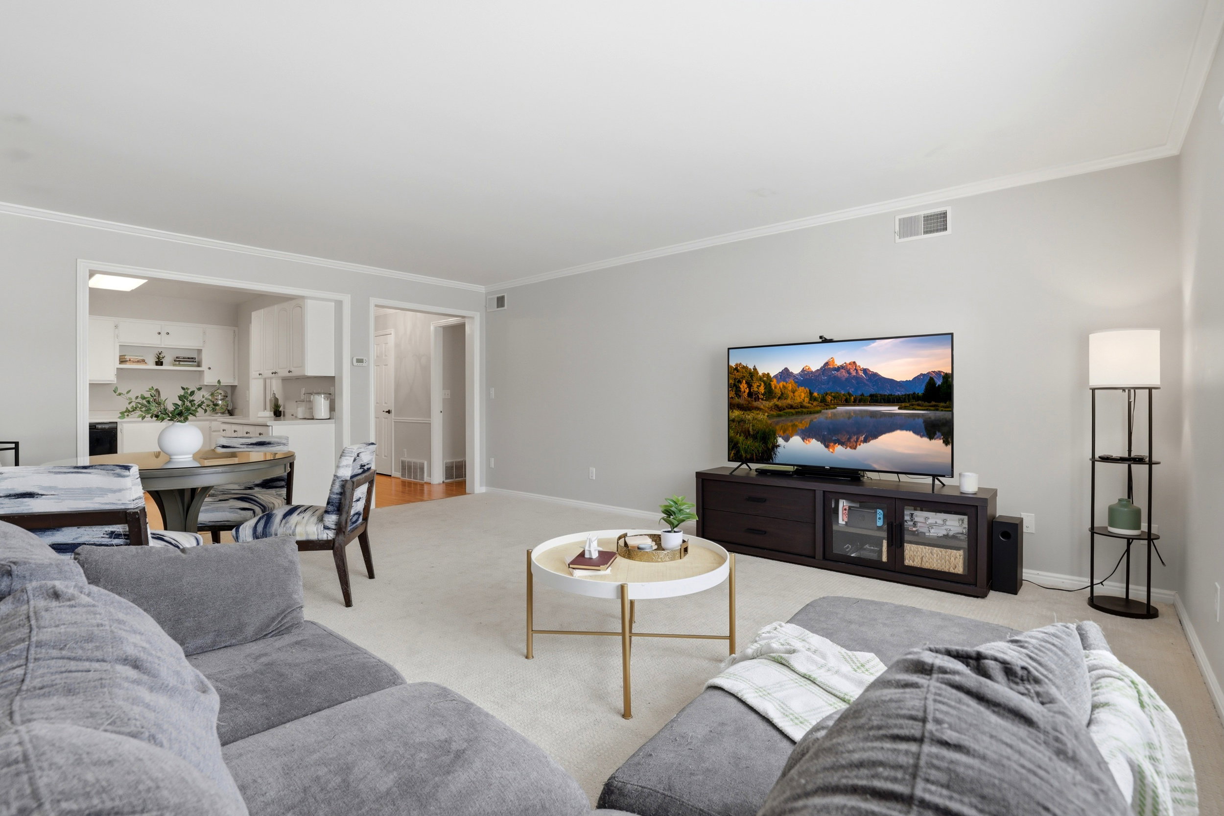 Living area featuring light carpet and ornamental molding