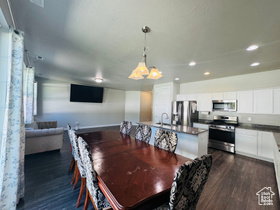 Dining room with dark wood-type flooring and recessed lighting