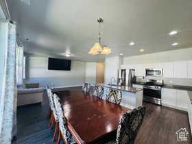 Dining room with dark wood-type flooring and recessed lighting