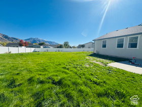 Fenced yard featuring a mountain view and a patio area