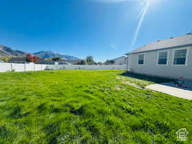 Fenced yard featuring a mountain view and a patio area