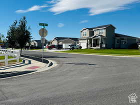 View of west street featuring traffic signs, sidewalks, a residential view, and curbs